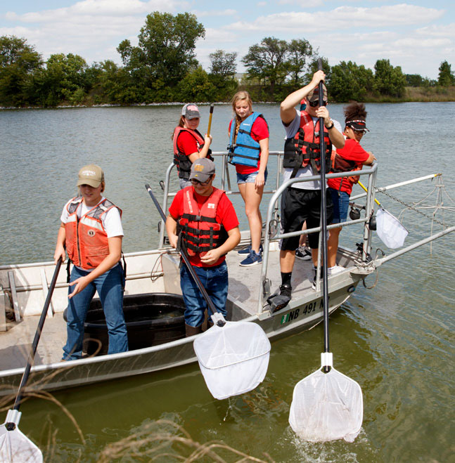 Students collecting specimens in a boat