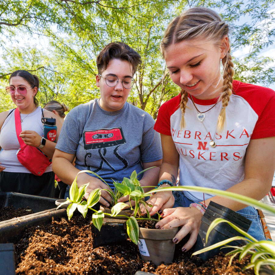 Shae Mitchell of Edison (center) and Emmy Oldham of Wellfleet add potting soil to the plants they received at the 2023 Well-being Fest.