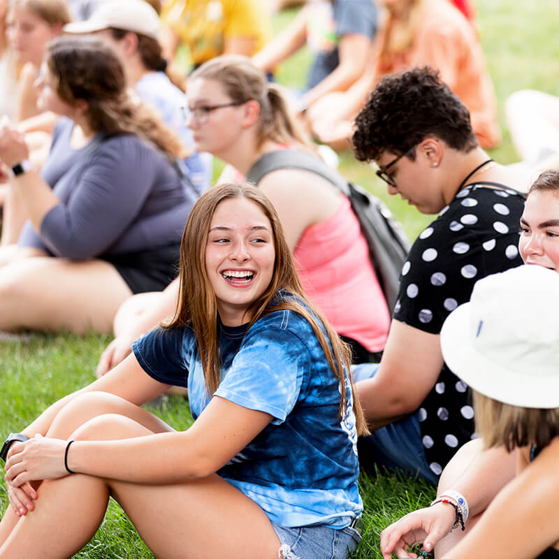 Students talking to one another while sitting outside