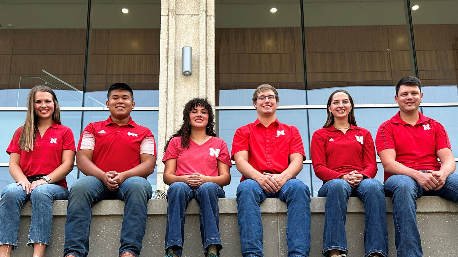 Students in red shirts posing for photo.