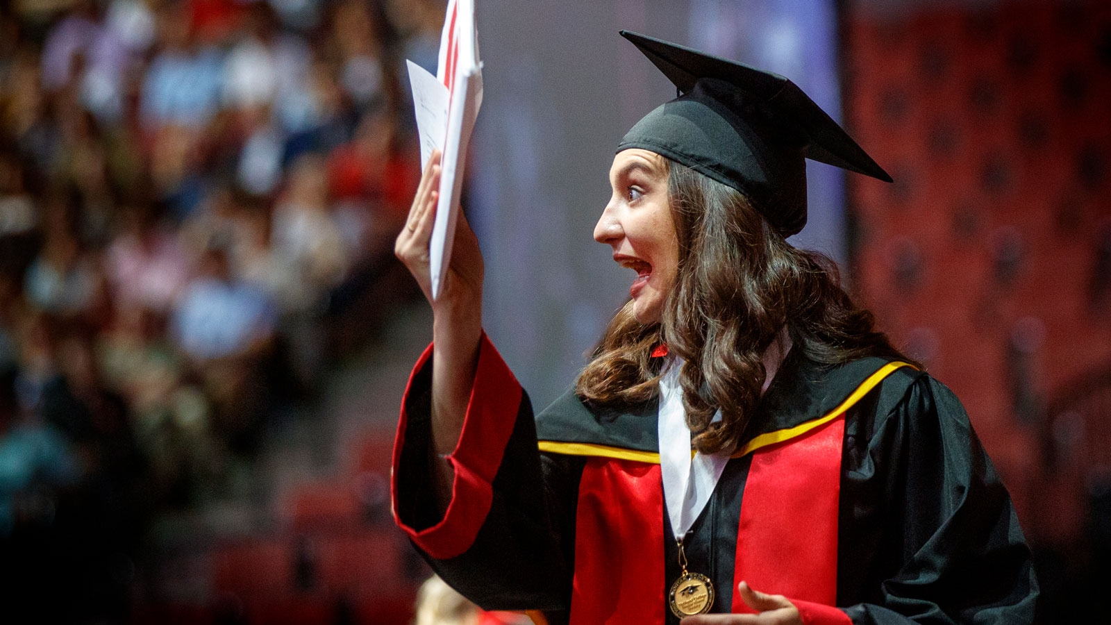 graduate holding diploma