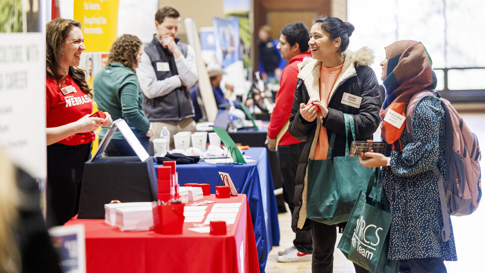 Two students talk with an employer at the Spring 2024 career fair