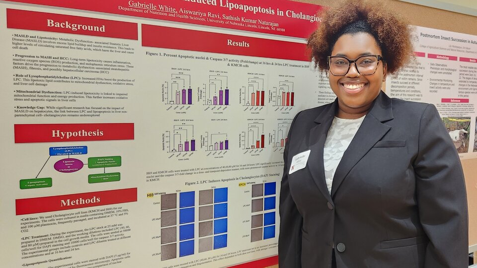 A student stands next to her poster at the 2026 Student Research Days Undergraduate Student Poster Session