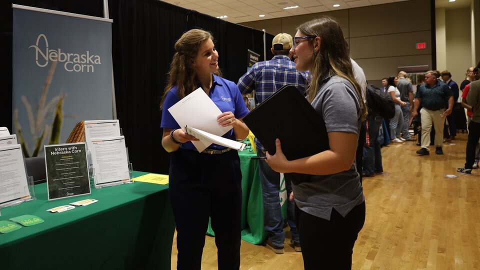 A student talks to an employer at the Fall 2025 career fair on East Campus.