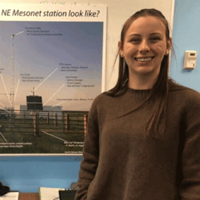 Camille Shifrin in front of Mesonet station poster