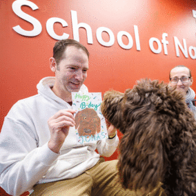 Kenneth Pyle showing Jonas the dog his 4th birthday card