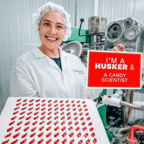 Tessa Porter in food lab with tray of red Nebraska gummies