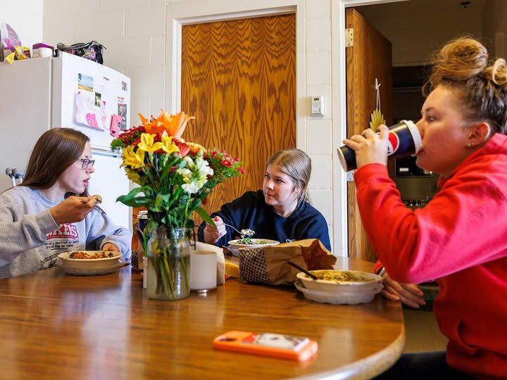 3 students eating at a kitchen table in the apartment in the Animal Science Complex