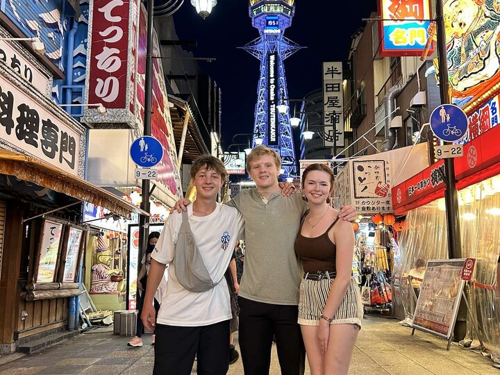 Three students pose for a picture on a busy street in Japan during an education abroad program.