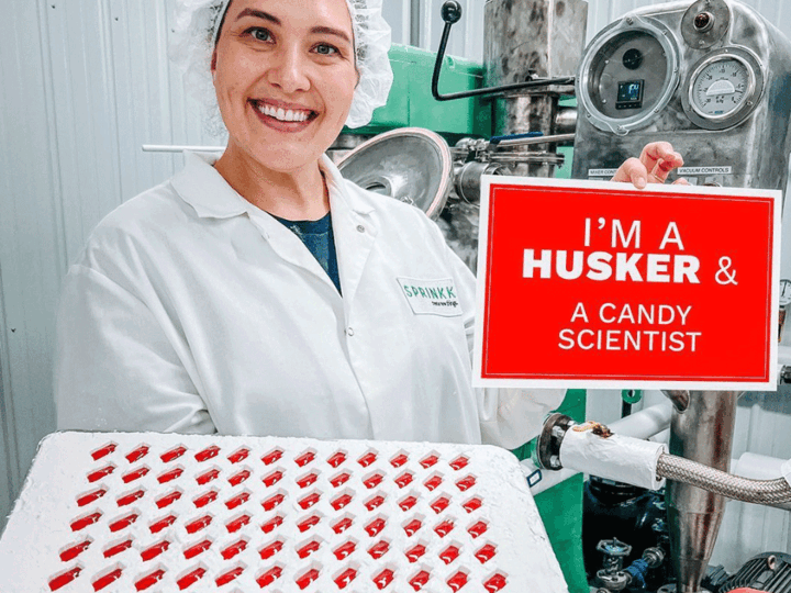 Tessa Porter in food lab with tray of red Nebraska gummies