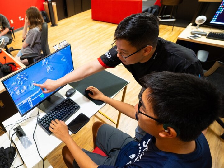 student and teacher using a computer