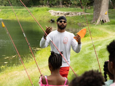 Elijah Riley teaching children about fishing