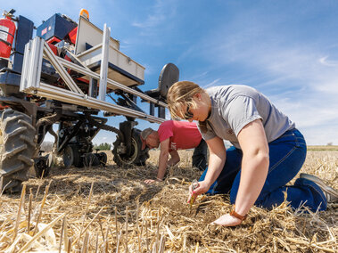 Graduate students follow behind the Flex-Ro at Rogers Memorial Farm