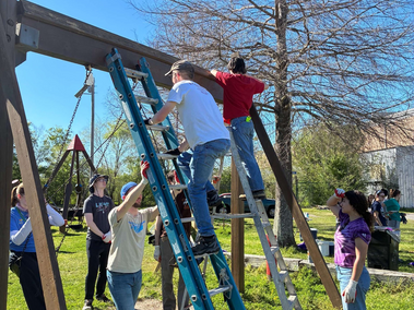 Students work on fixing a playground in New Orleans that was damaged by a storm