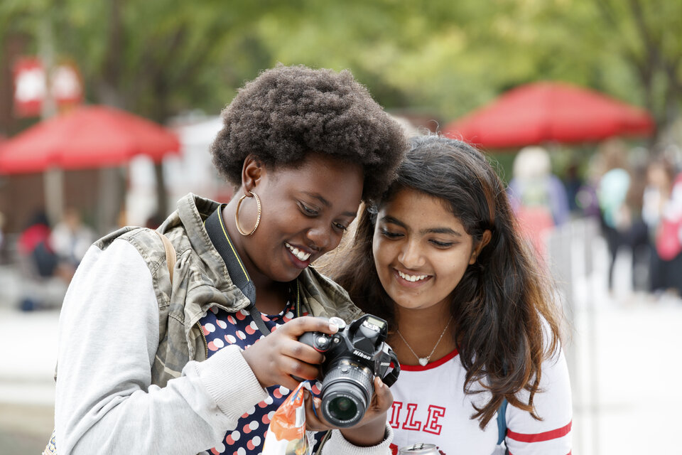 students look at photo on camera